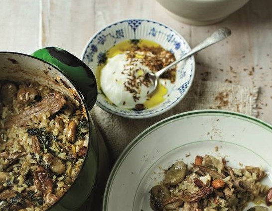 Goat pilaf served on a plate with yoghurt and torn mint 