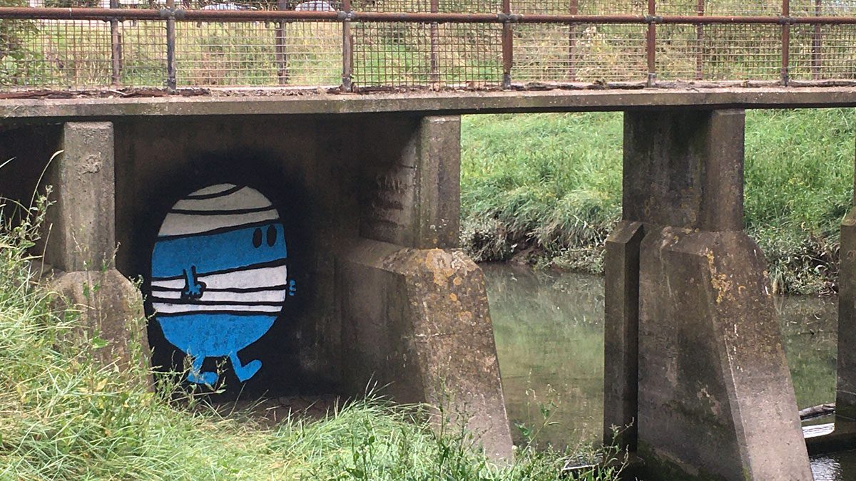 Mr Bump painted under a footbridge