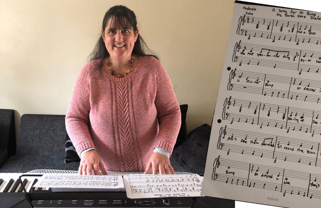 A woman stands behind a piano keyboard