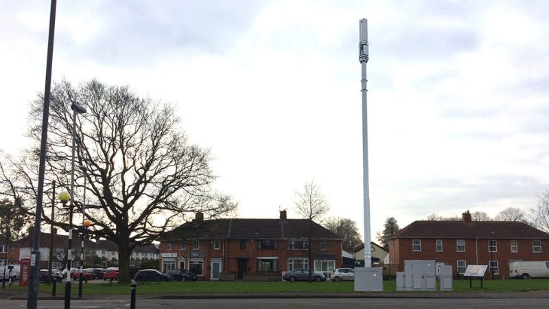 large mast towers over houses in a residential area
