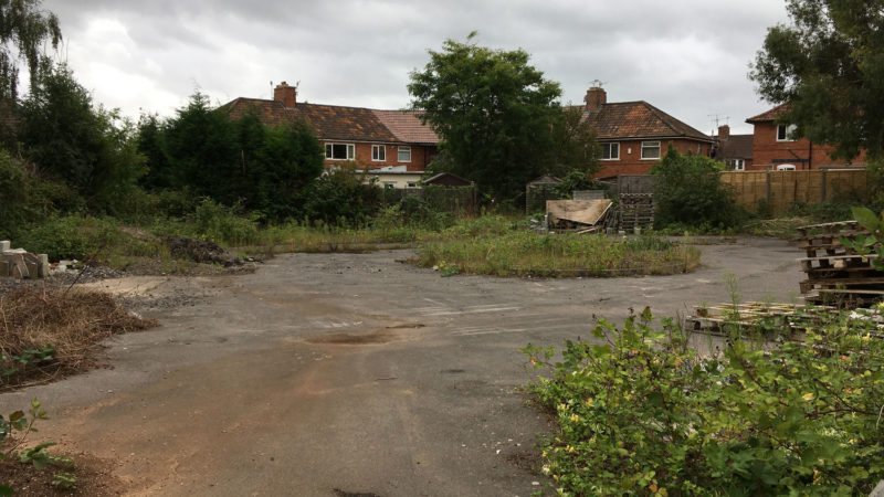 Small car park with houses in the background
