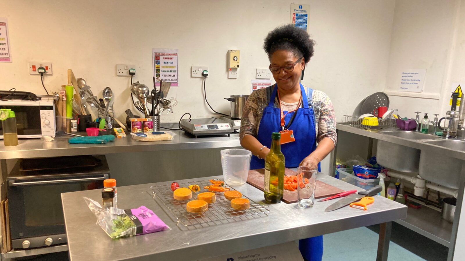 A woman stood in a kitchen chopping carrots while making soup