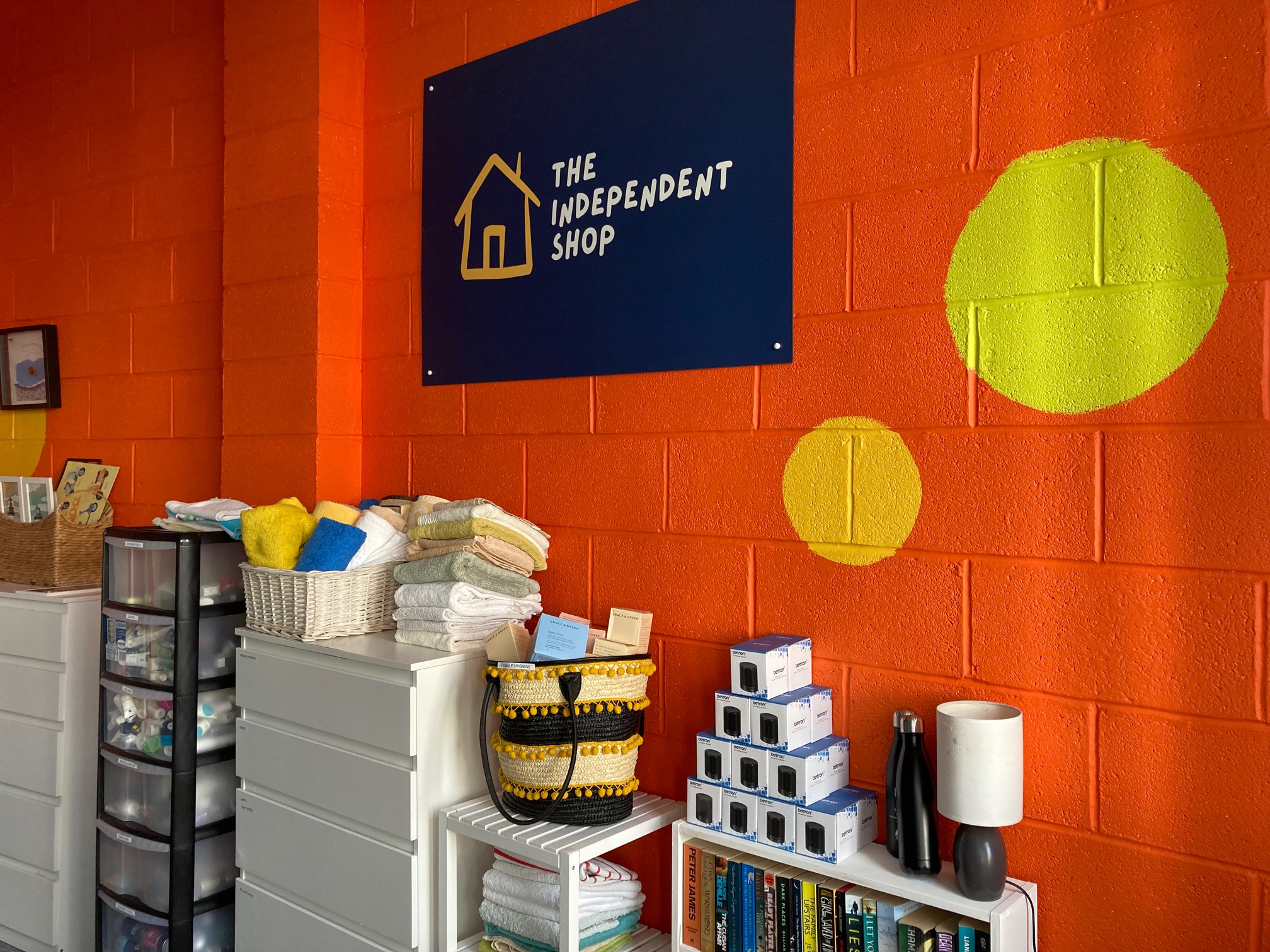 Inside a colourful independent shop with shelves full of essential items