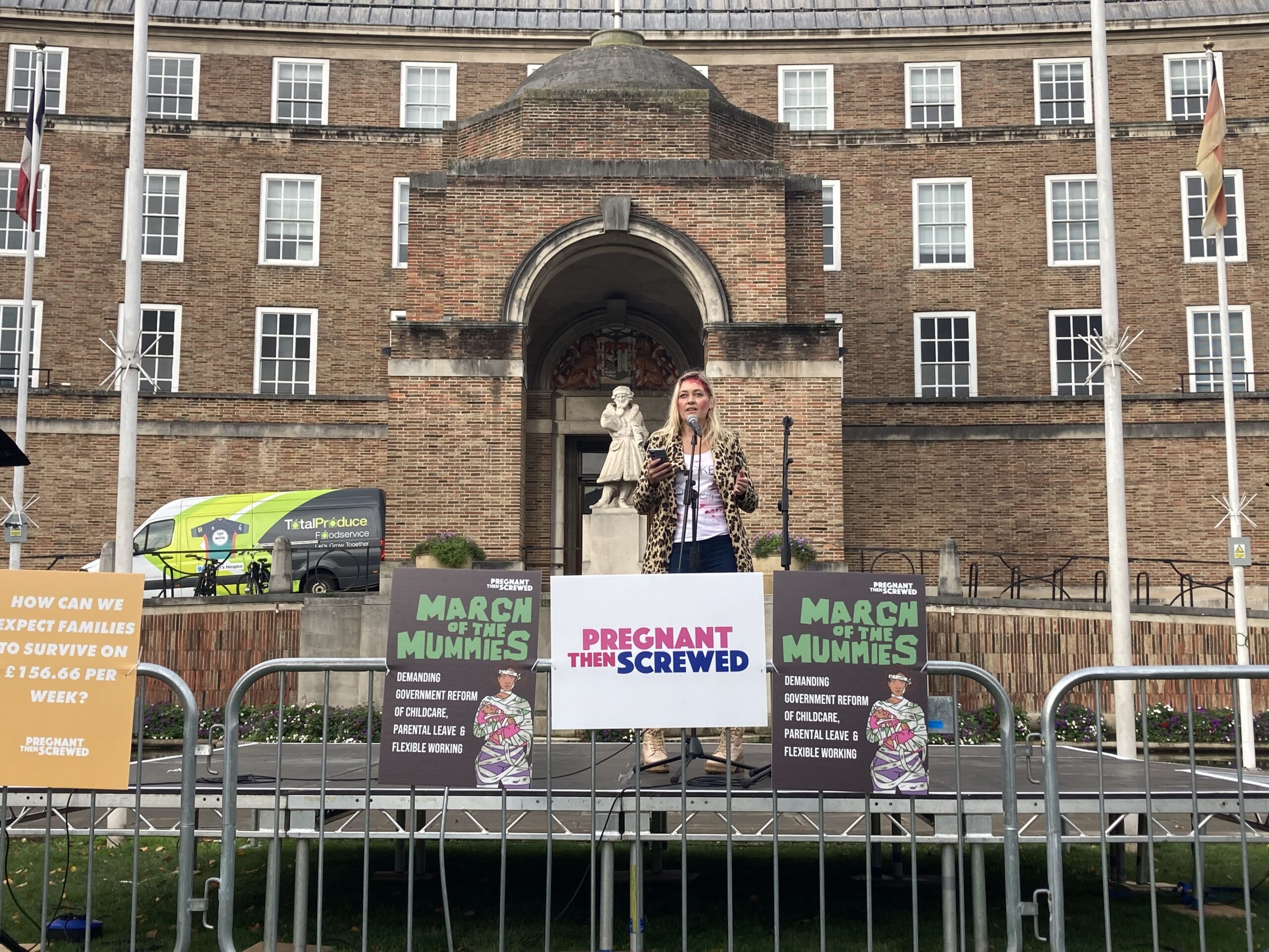 A woman speaking into a microphone at a March of the Mummies protest