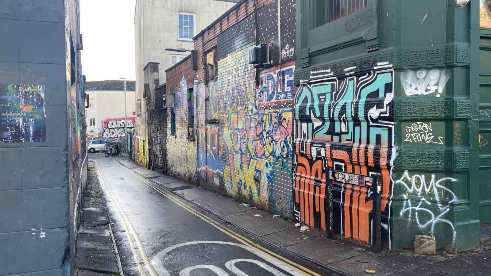 A narrow alleyway with graffiti on the walls