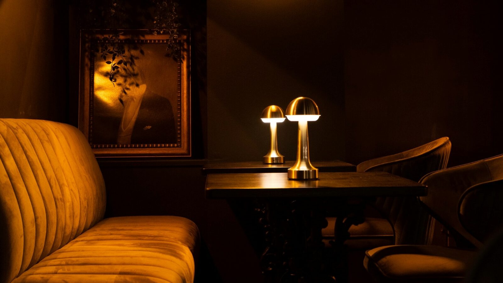 A banquette, table and chairs with framed art on the wall