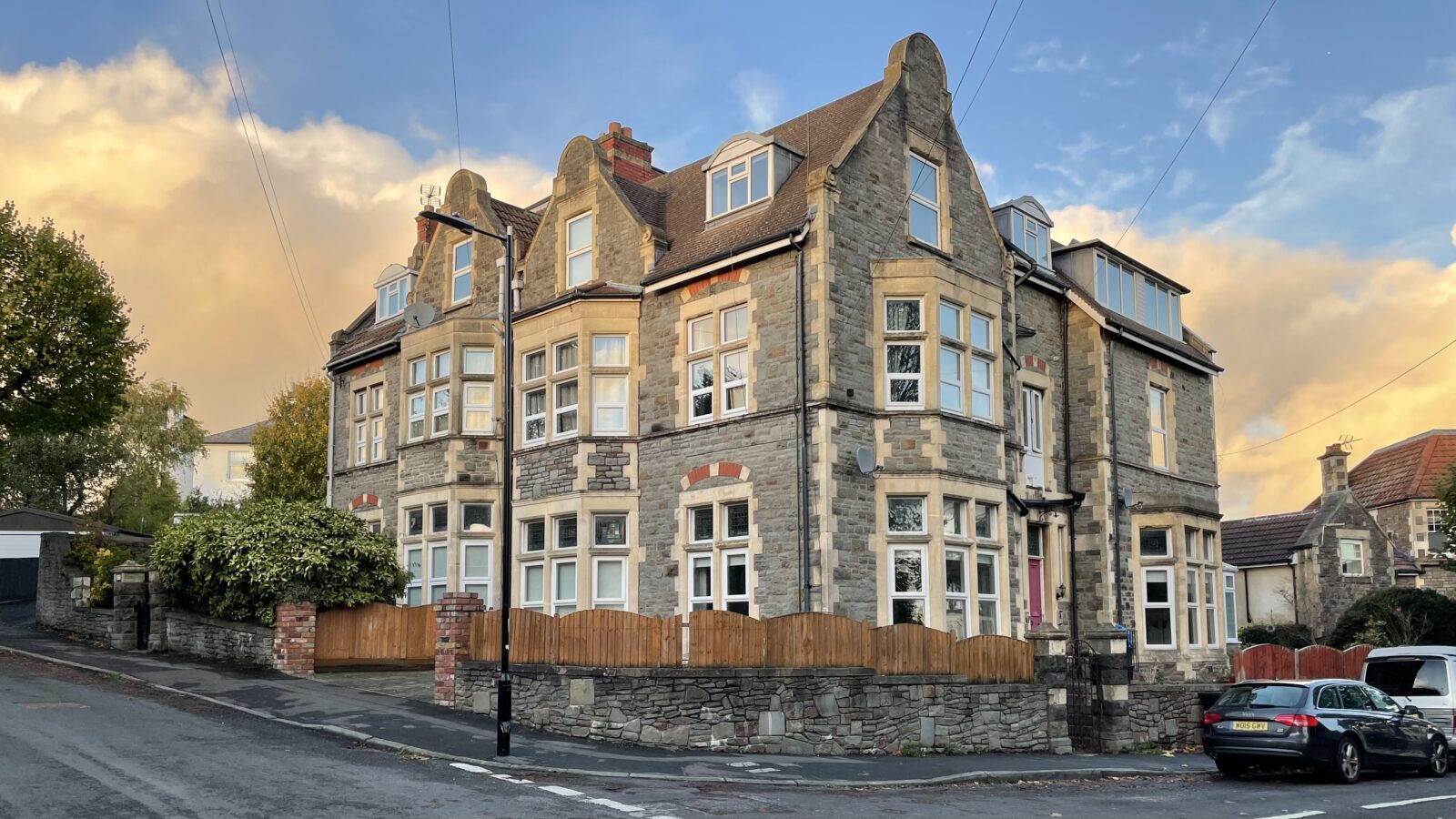 The house in Bristol that was the student house in The Young Ones; a three-storey building with cars parked outside and a clear blue sky with a few clouds