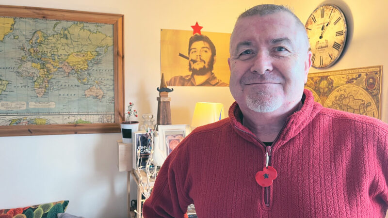 Robin stands in the living room of his small flat