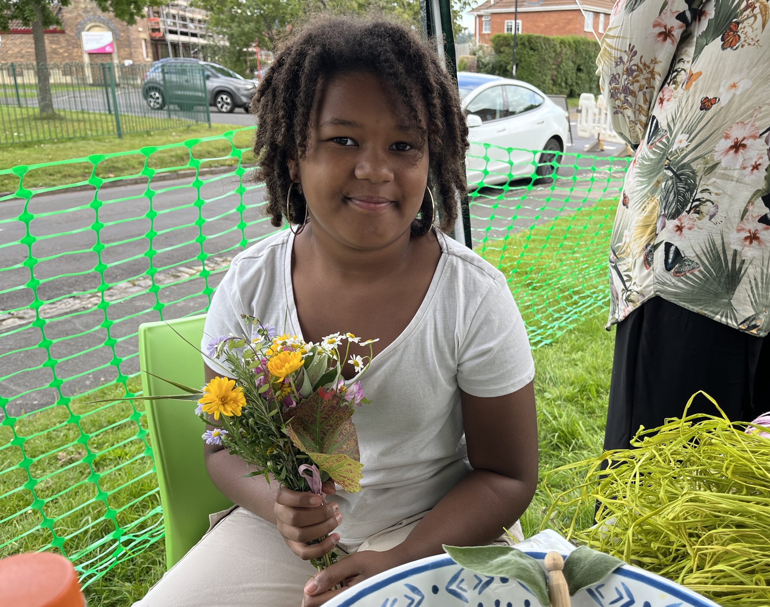 A young child holds a small bouquet of colourful flowers