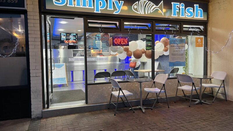 The exterior of a fish and chip shop - lit up in the evening
