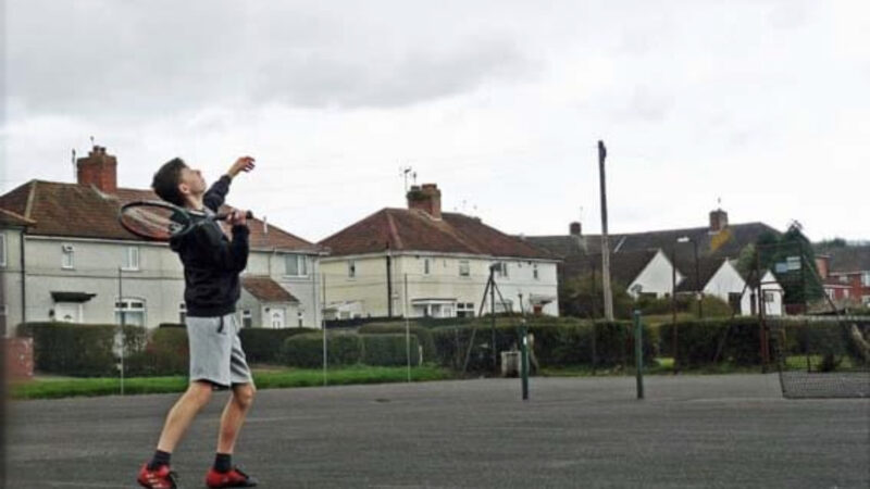 A young man plays a tennis stroke