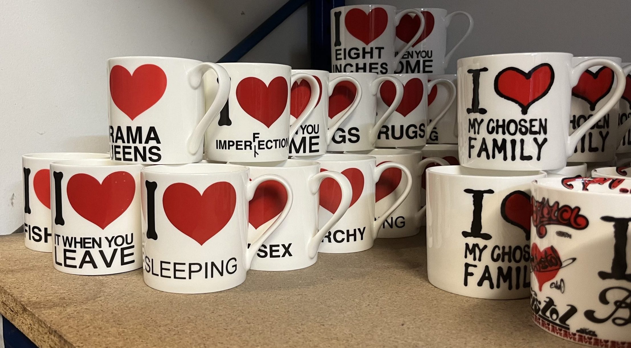 Lighthearted mugs are stacked on a shelf