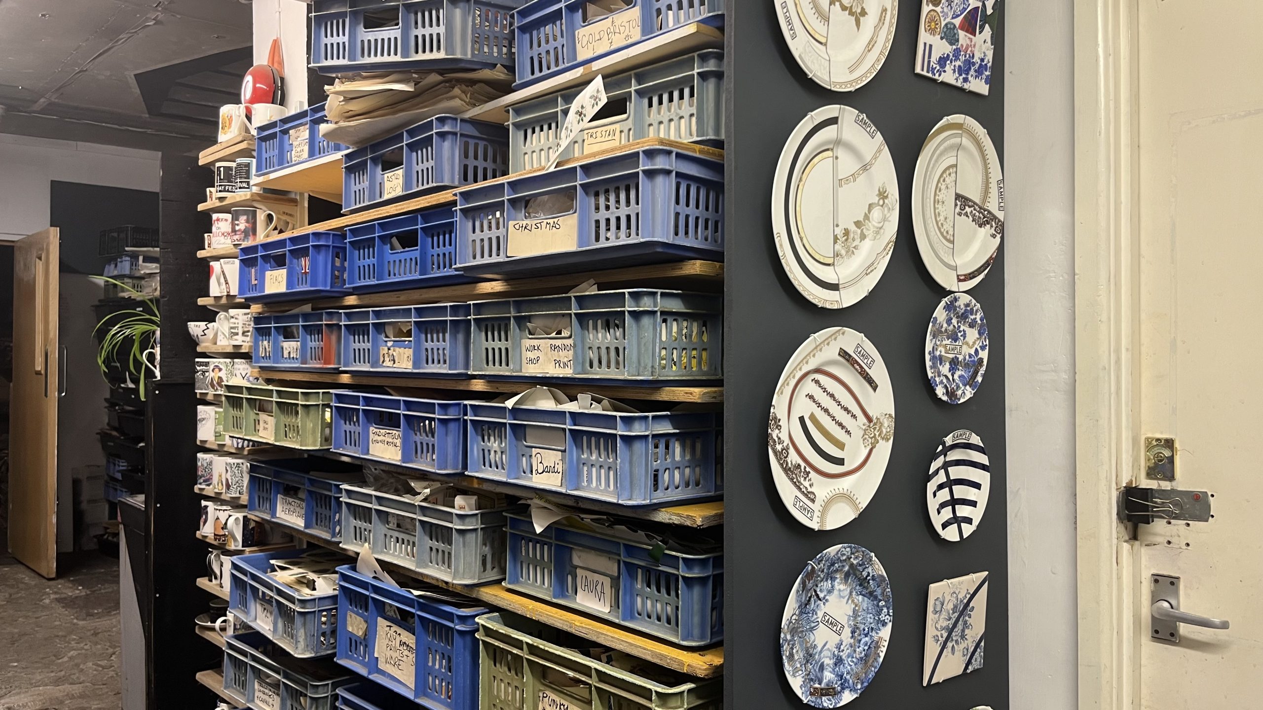 Boxes containing transfer prints and stacked in draws adorned with decorative plates. 
