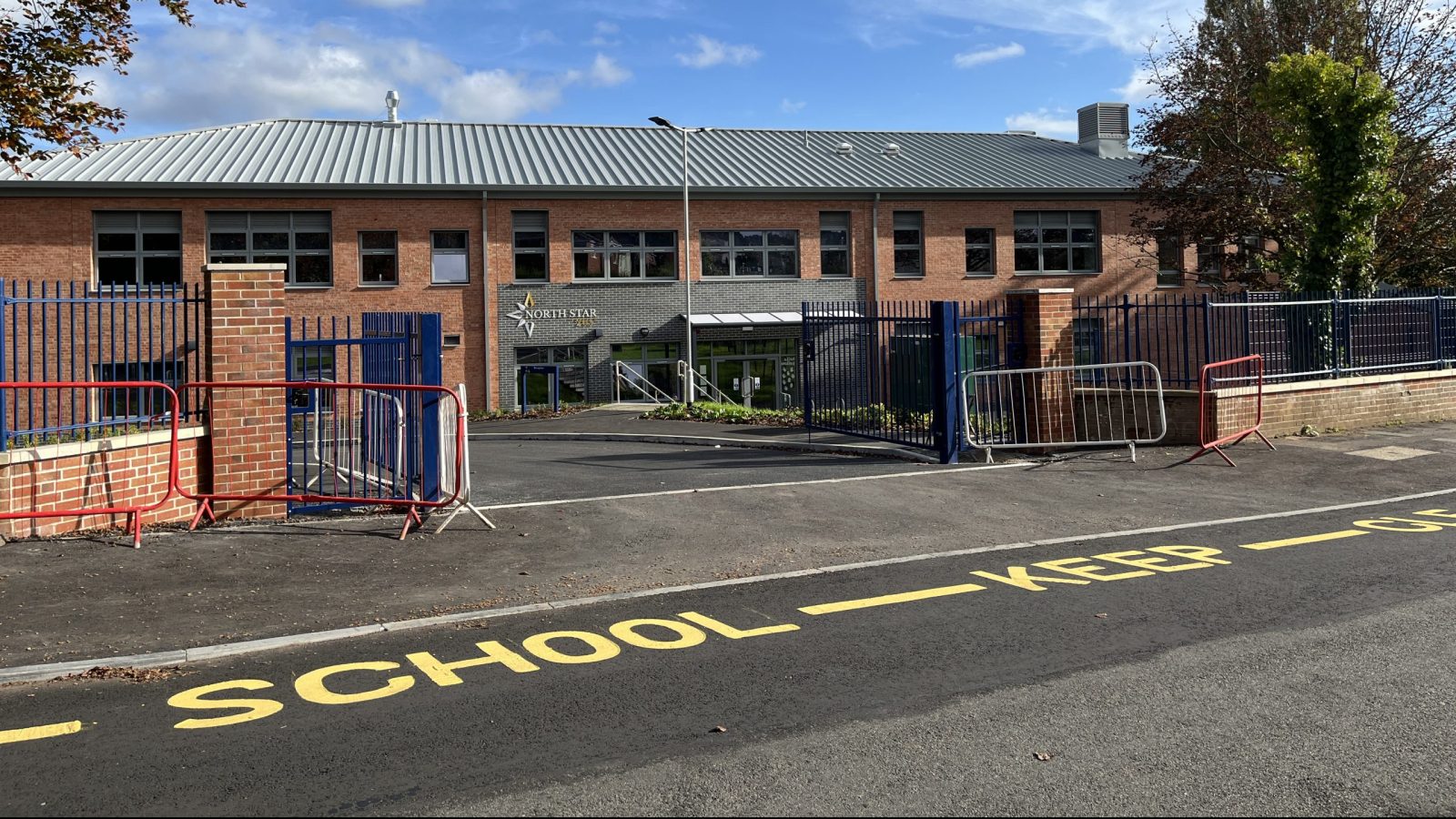Red brick school building with a grey metal roof