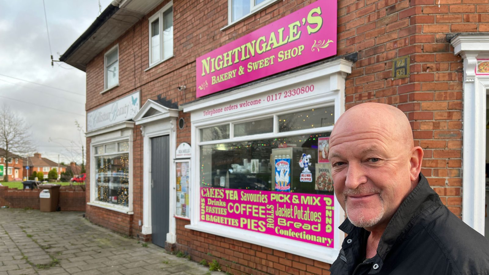 A man stands outside a shop called Nightingales bakery and sweet shop