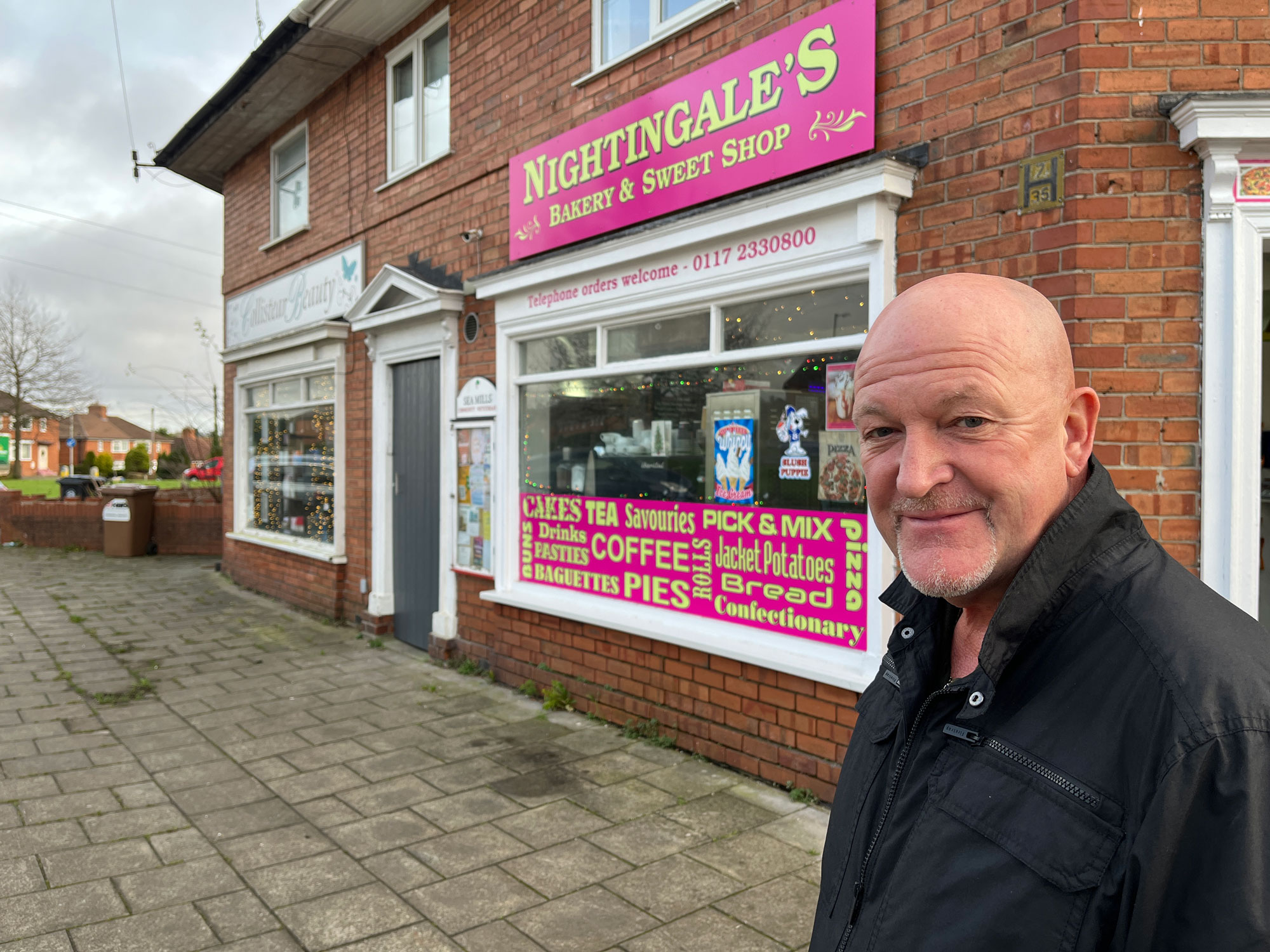 A man stands outside a shop called Nightingales bakery and sweet shop