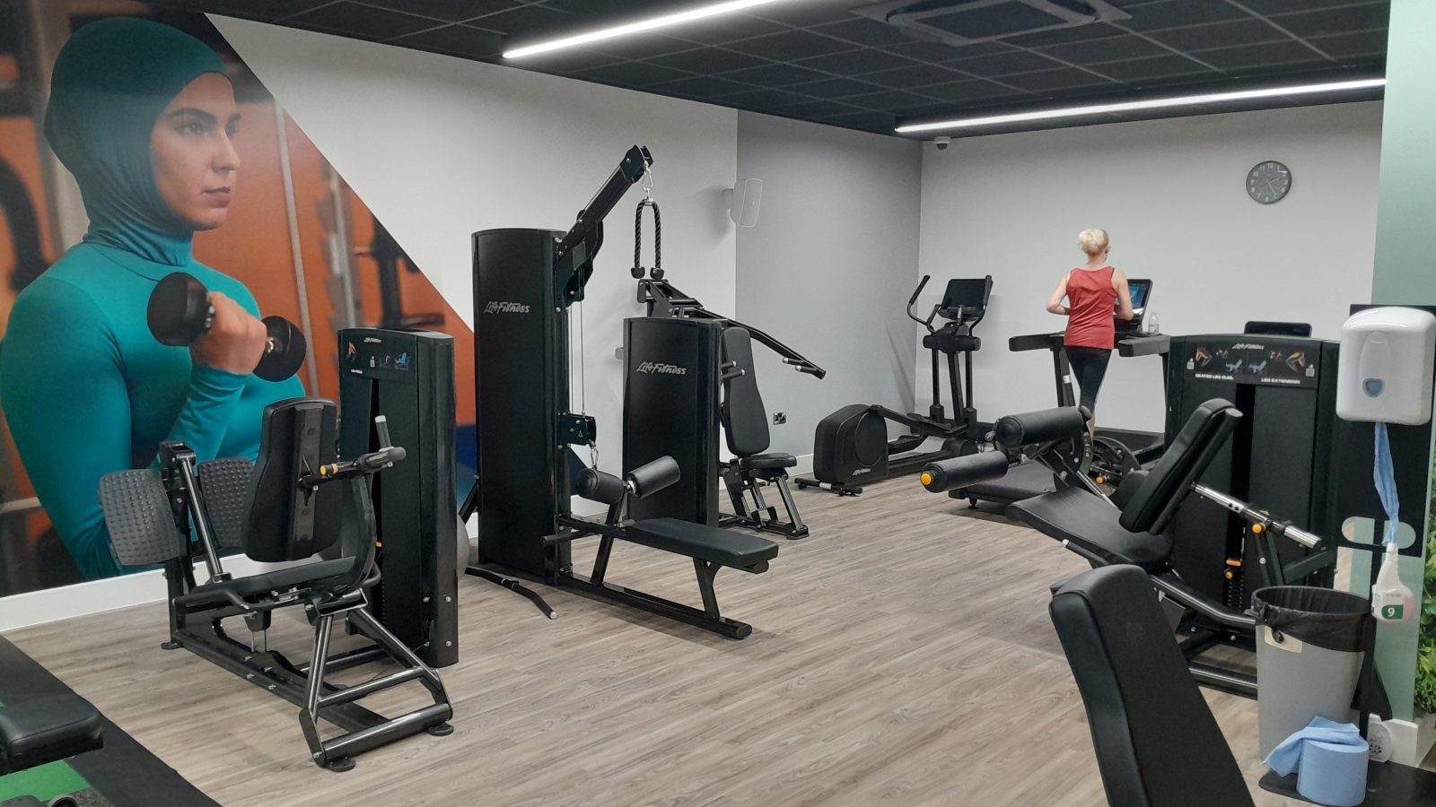 Women-only gym space with lone woman on treadmill