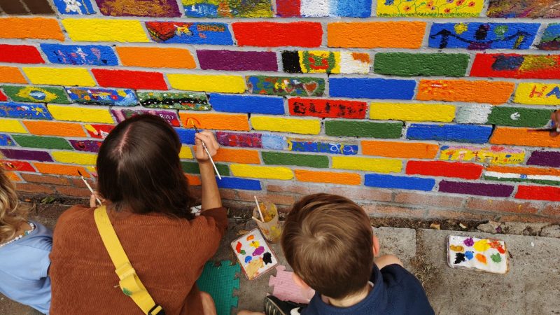 Hundreds help turn graffiti-hit wall into colourful mural